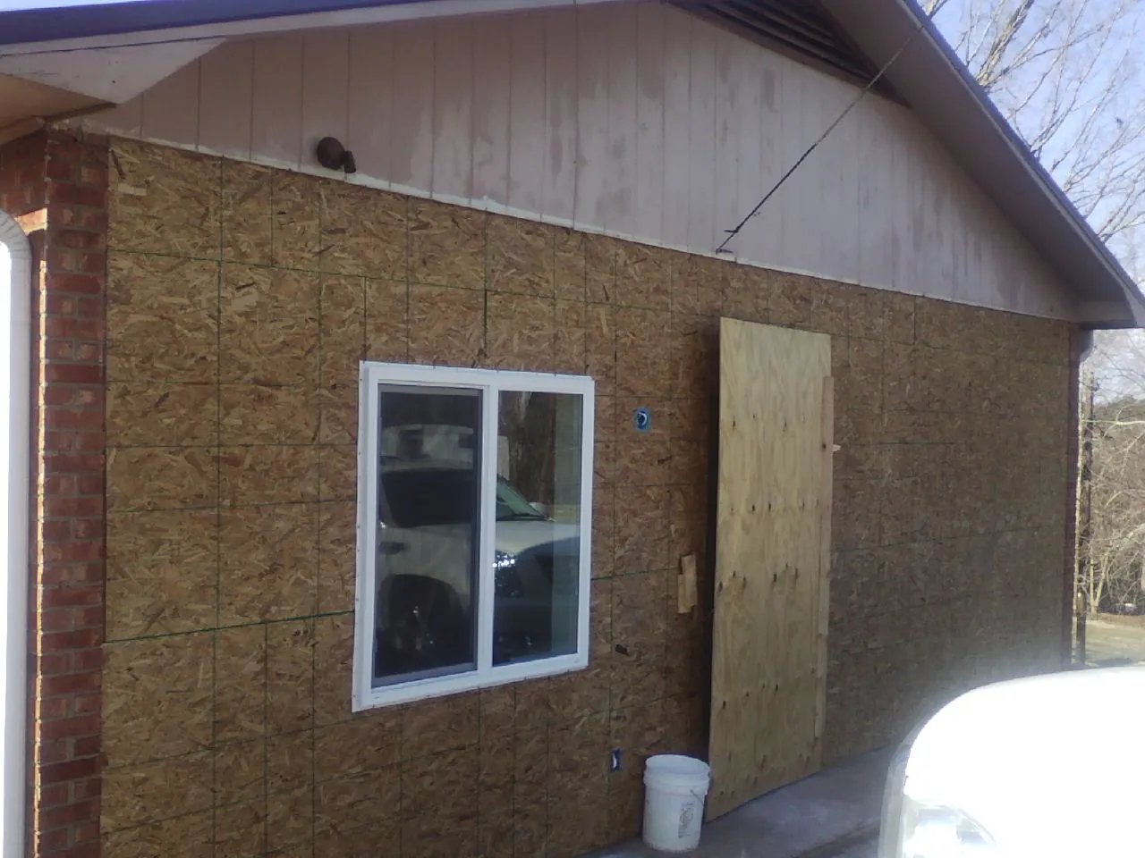 OSB sheathing on a garage addition wall before siding in Balsam