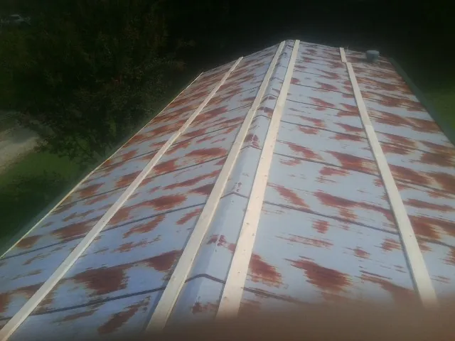 Rusted metal roof panels with new wood purlins before replacement — Storm Damage Roof Repair in Balsam by Roofing Brothers