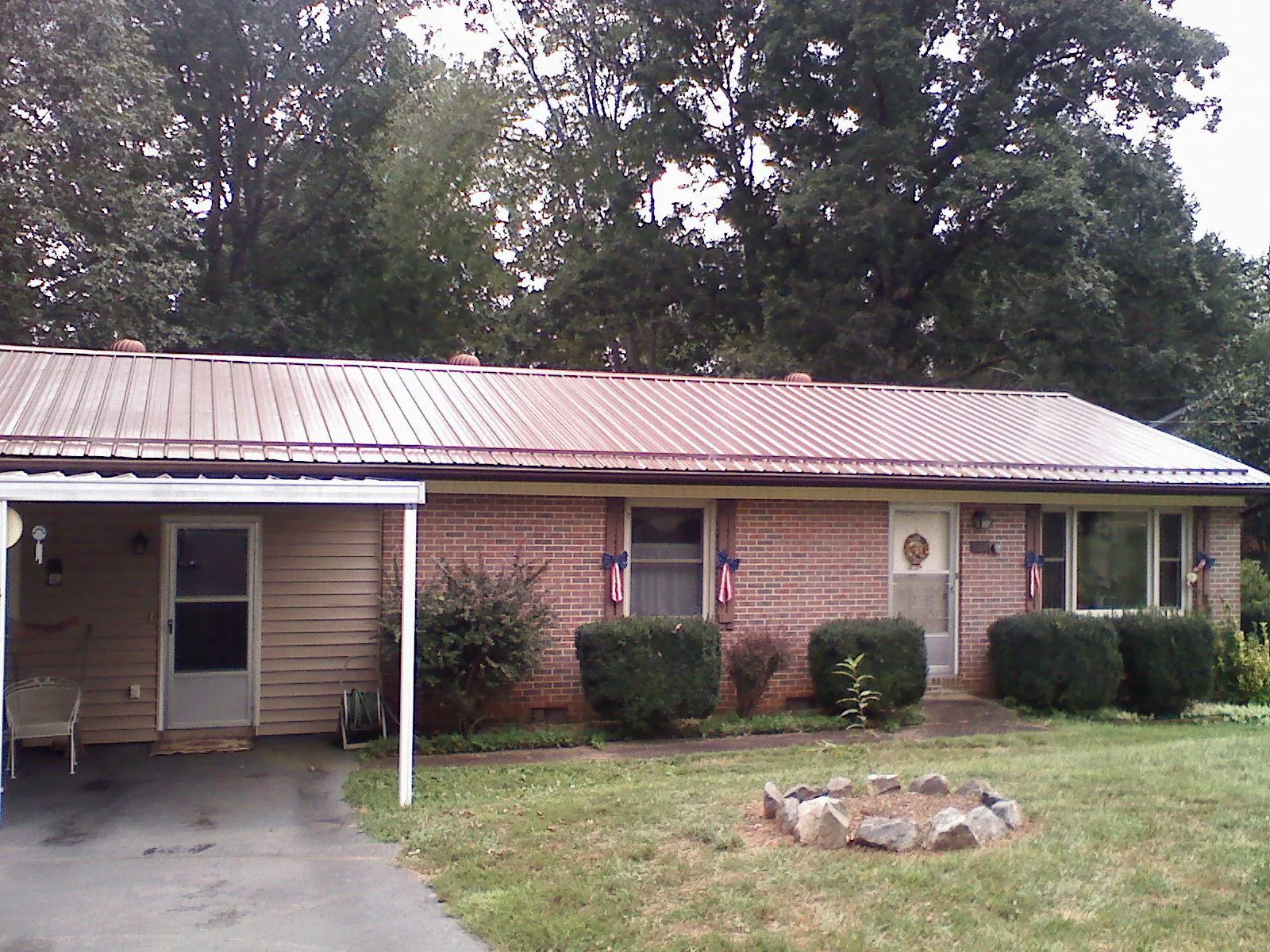 Bronze metal roof and carport on a brick ranch home — Roof Repair work by our crew in Balsam